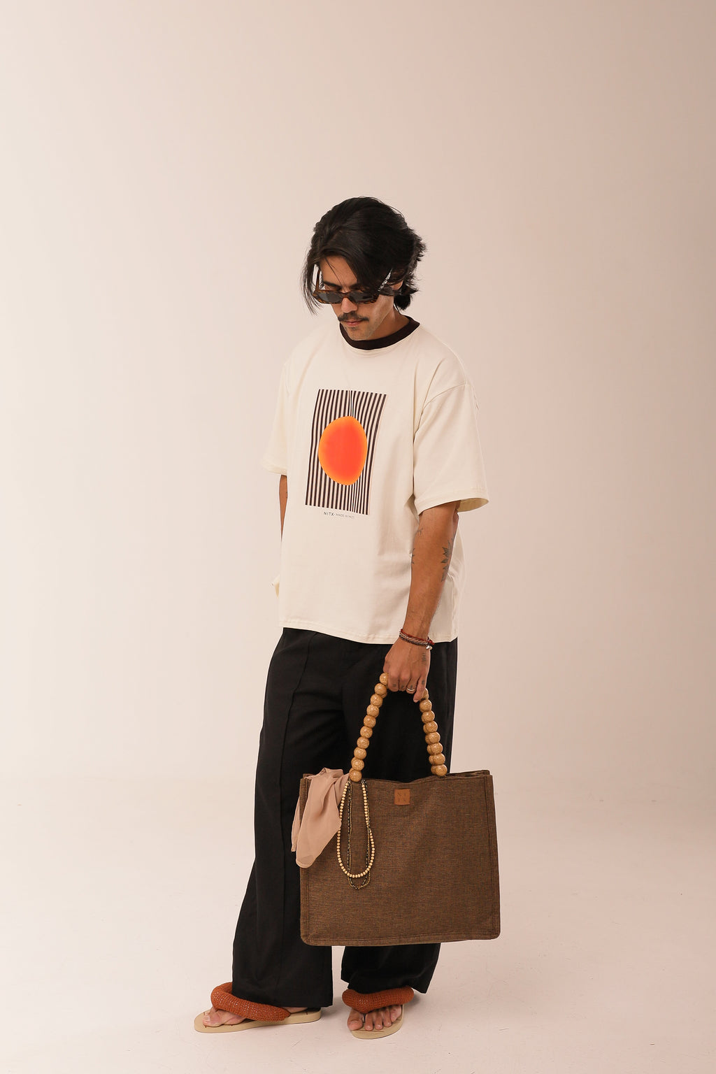 T Shirt Over Sol Sagrado NITX Off White vista frontal com bolsa